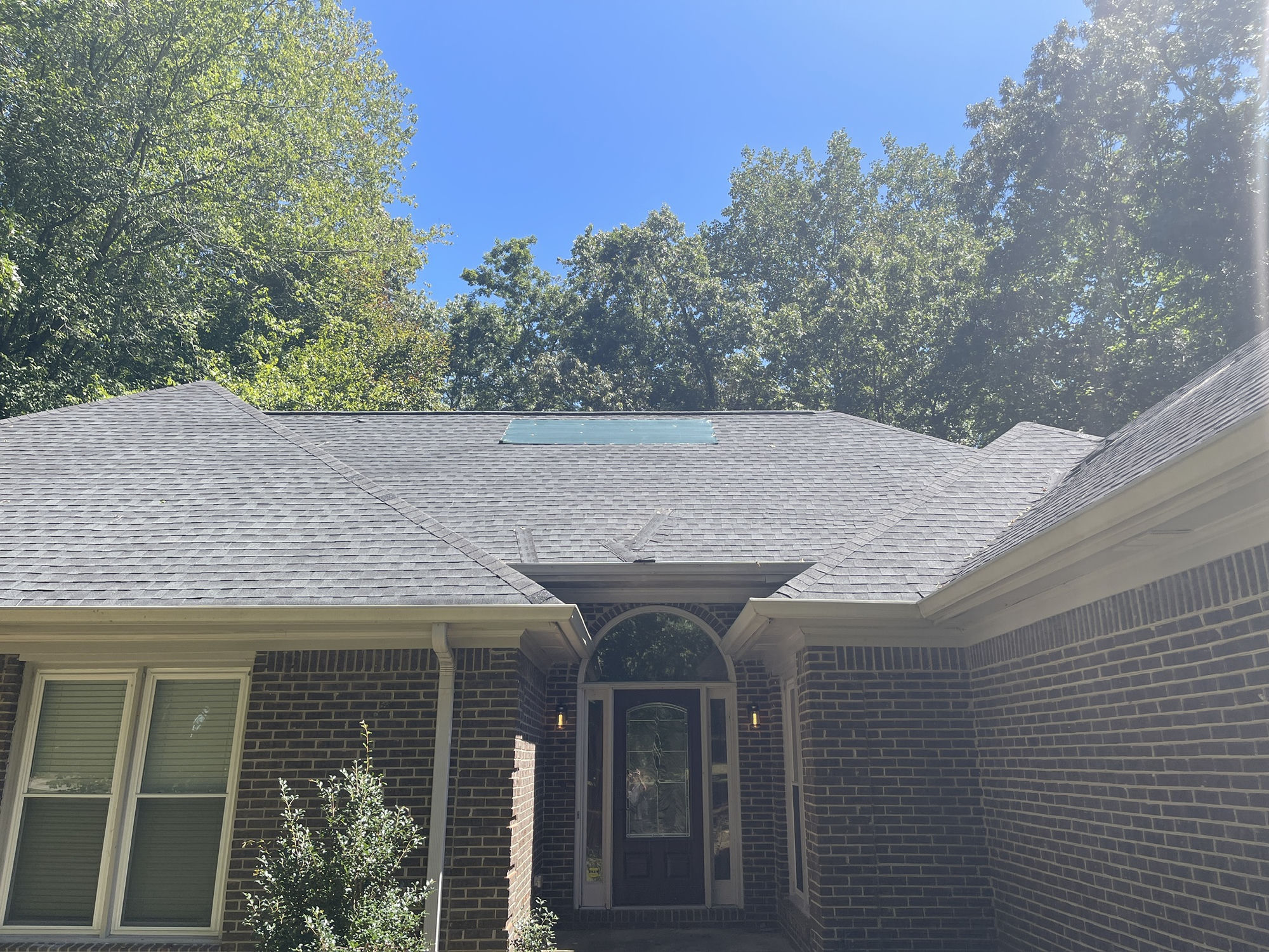 A tarp screwed over the failed section directly above the front door.